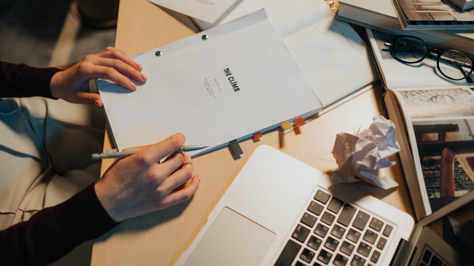 An investor at a desk with a laptop and an espresso, looking through pitch notes
